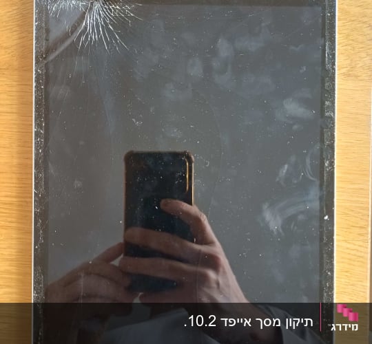 מסך אייפד שבור עם השתקפות של ידיים